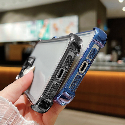 Person holding two phone cases, one clear and one blue, with a blurred indoor background.